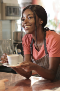 teen in pink tee and apron works as barista